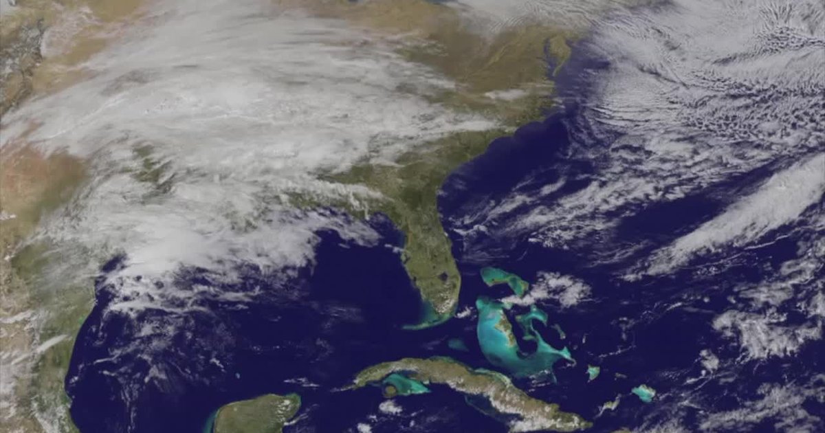 NOAA GOES satellite view of a storm system crossing the United States, illustrating the wet-and-snowy western half and warm eastern half expected for Halloween 2026
