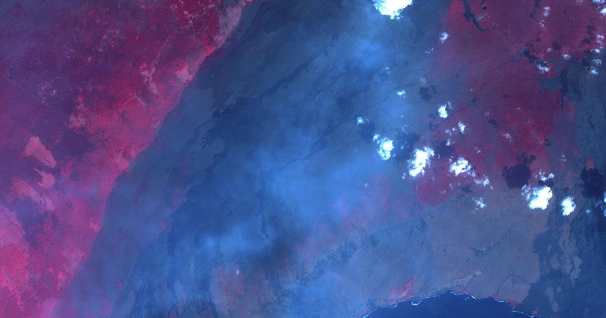 Kilauea volcano erupting at night with lava fountains illuminating the sky above Halemaumau crater, with volcanic gas plume visible against the stars